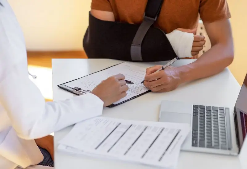 Doctor and patient filling out medical insurance forms