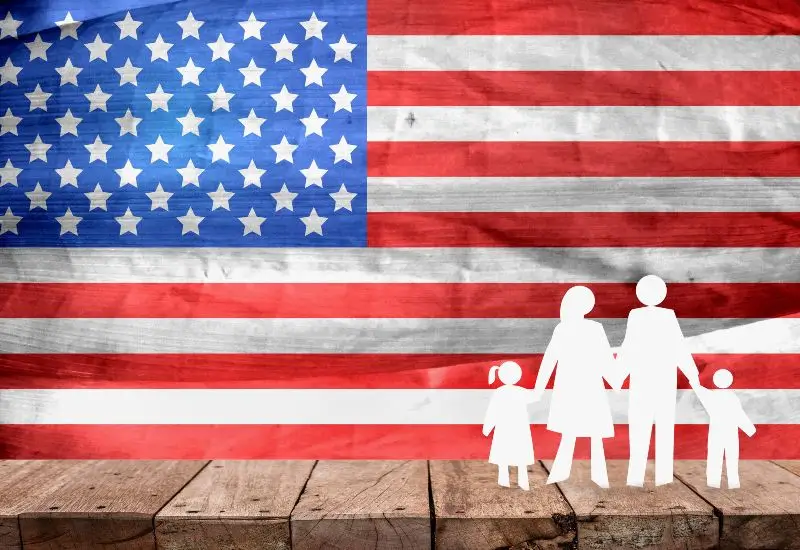 Family of four standing in front of United States flag